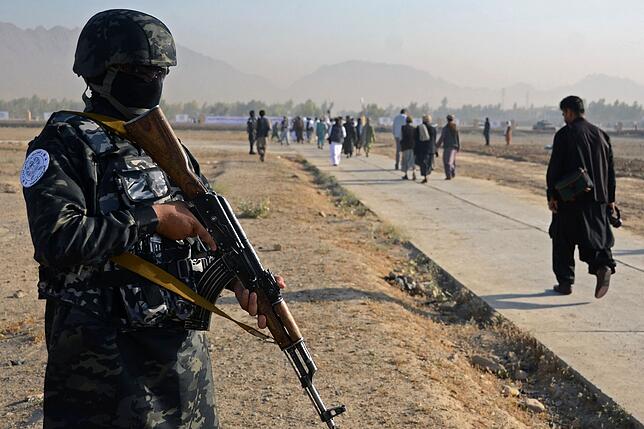Ein Kämpfer der Taliban steht in Kandahar (Afghanistan) Wache, während Muslime sich zu dem Eid al-Fitr-Gebet begeben.