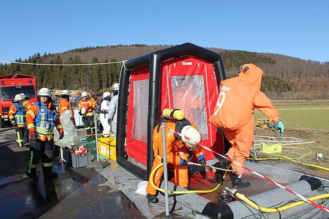 Die Kräfte des Gefahrgutzugs müssen nach ihrem Einsatz durch die Dekontaminationsschleuse.