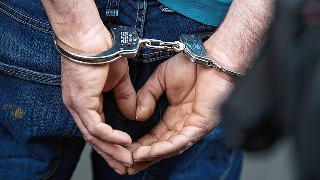 Ein Mann mit Handschellen. (Symbolbild) Vor 30 Jahren in Niederwihl im Hotzenwald nimmt die Polizei einen Schweizer Offizier fest.