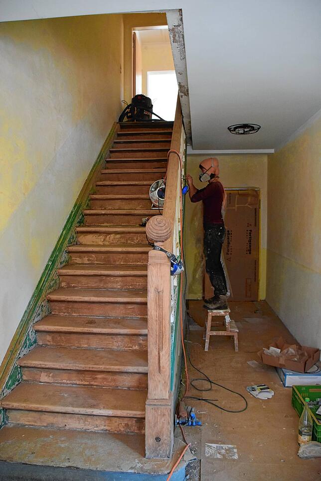 Im Zeiserhof läuft der Umbau: Hier schleift eine Helferin die Treppe ab.