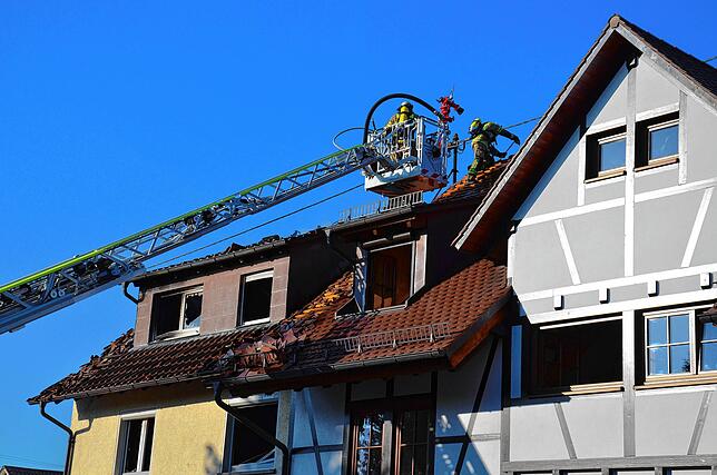 Die Feuerwehr öffnet etwa zwei Stunden nach Einsatzbeginn auch den Dachstuhl des Nachbarhauses.