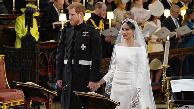 Harry und Meghan stehen Hand in Hand vor dem Altar.