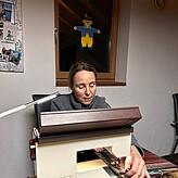 Marlies Riegger näht die Wollfäden auf das Nahtband.