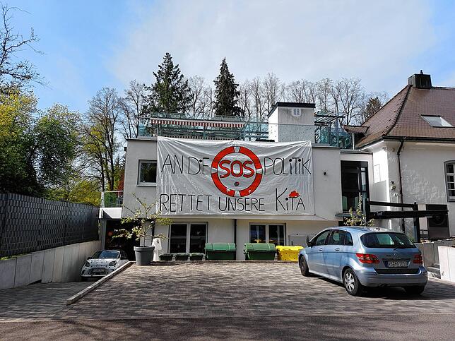 So fing alles an. An der Kindertageseinrichtung Kikripp hängt ein großes Protestplakat am 1. Mai 2024 – die Kita steckt in ...