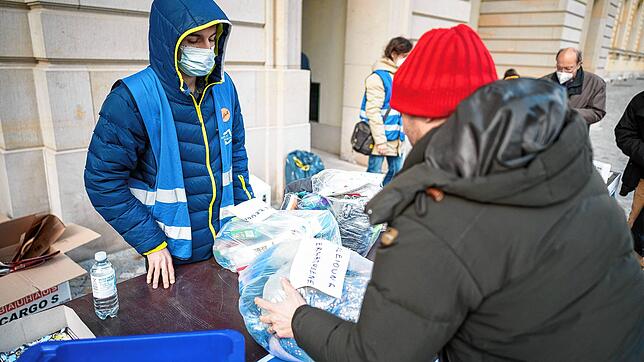 Helfer geben Spenden an Geflüchtete aus der Ukraine aus.