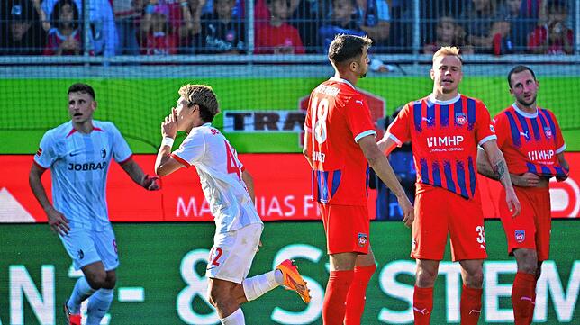Ritsu Doan (M) vom SC Freiburg feiert seinen Führungstreffer, während die Heidenheimer enttäuscht daneben stehen.