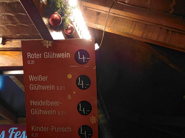Tafel mit den Preisen im Glühweinstand am Hafen.