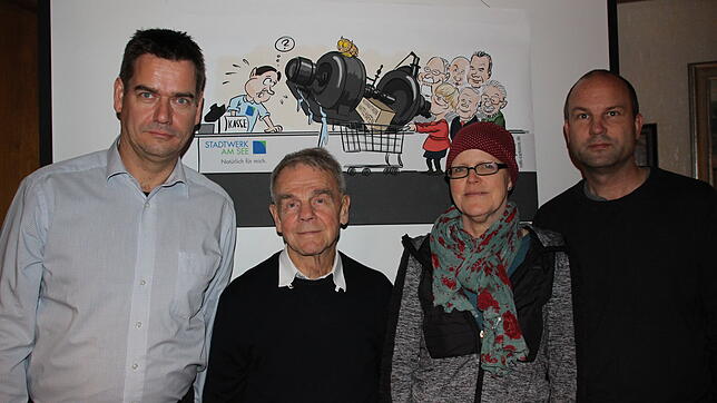 Die Mitglieder des Vereins Bürgerenergie stehen vor der Karikatur von Stefan Roth: Eric Hueber (von links), Joachim Betten, Silke ...