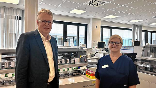 Klinikgeschäftsführer Matthias Geiser und Laborleiterin Petra Saile stehen vor der neuen Laborstraße, die vor Kurzem in Betrieb genommen ...