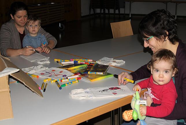 Die Krabbelgruppe im Basteleinsatz. Zusammen mit den Muttis wird für den Kleiderbasar gebastelt und geklebt, was den Kindern viel Spaß ...