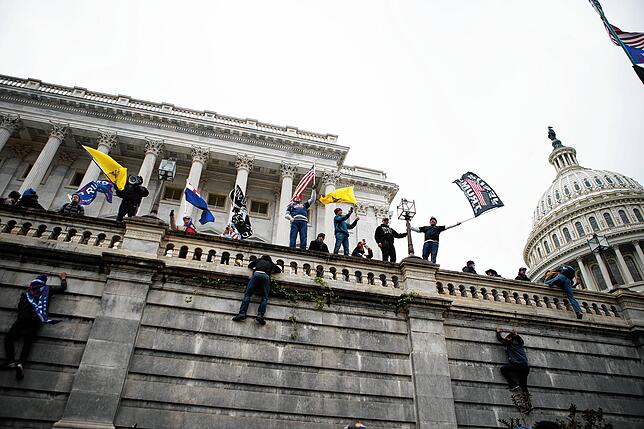 Anhänger von Präsident Donald Trump klettern in Washington auf die Westwand des US-Kapitols.