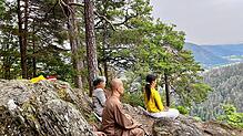 Vor der Gehmeditation lassen sich Mönch Thich Dao Chanh (Mitte) und Yogalehrerin Binh Le Thi (rechts) sitzend auf den Ort ein. Bild: ...