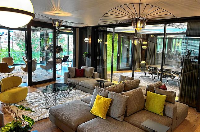 Der Lounge-Bereich neben der Küche. Dahinter schließt sich die Loggia an – mit Hängesesseln und großen Fensterflächen. „Ein Arbeitsplatz ...