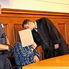 Der Angeklagte verbirgt sein Gesicht hinter einem Aktendeckel, während er mit seinem Verteidiger Benjamin Waldmüller spricht.