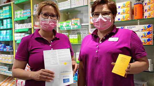 Die Apothekerinnen Melanie Krämer (links) und Roswitha Oßwald zeigen, wie das Zertifikat mit dem QR-Code aussieht. Damit können Geimpfte ...
