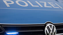 Ein Blaulicht leuchtet im Kühlergrill eines Polizeiautos.