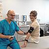 Der Internist Jonas Korsakas misst seiner Patientin Gisela Niedermann den Blutdruck. Sie hat am Telemonitoring-Projekt teilgenommen.