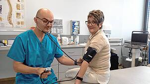 Der Internist Jonas Korsakas misst seiner Patientin Gisela Niedermann den Blutdruck. Sie hat am Telemonitoring-Projekt teilgenommen.