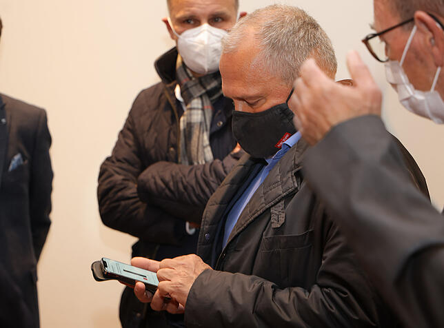 Blick auf das Mobiltelefon, dass ihm eine erhebliche Wahlniederlage bestätigt. OB Martin Staab im Kreis der Kollegen Bernd Häusler und ...