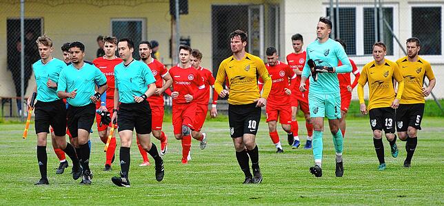 Die Mannschaft des FC Gutmadingen in gelb und des FC Bad Dürrheim in rot marschieren auf den Platz