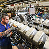 Ein RRPS-Mitarbeiter arbeitet in Friedrichshafen an einem Dieselmotor.