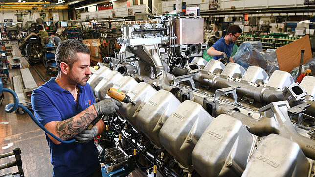 Ein RRPS-Mitarbeiter arbeitet in Friedrichshafen an einem Dieselmotor.