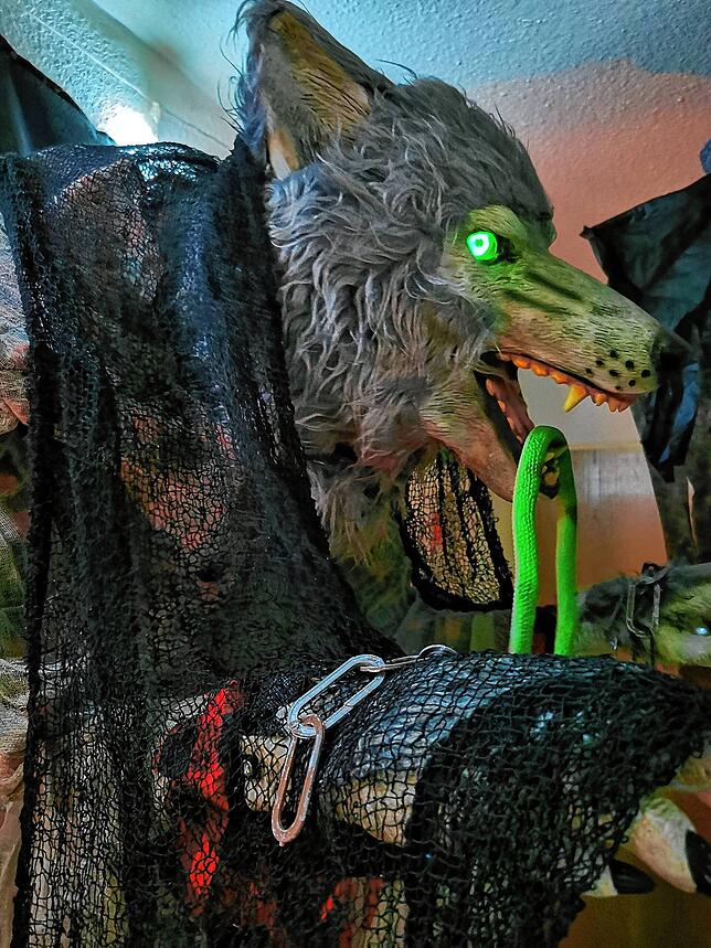 Der mehr als zwei Meter große Werwolf mit grün leuchtenden Augen und Mamba im Maul brüllt furchteinflößend.