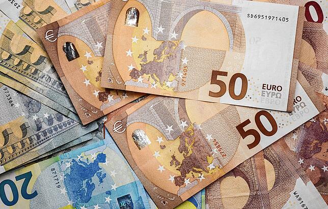 Zahlreiche Euro-Banknoten liegen auf einem Tisch.