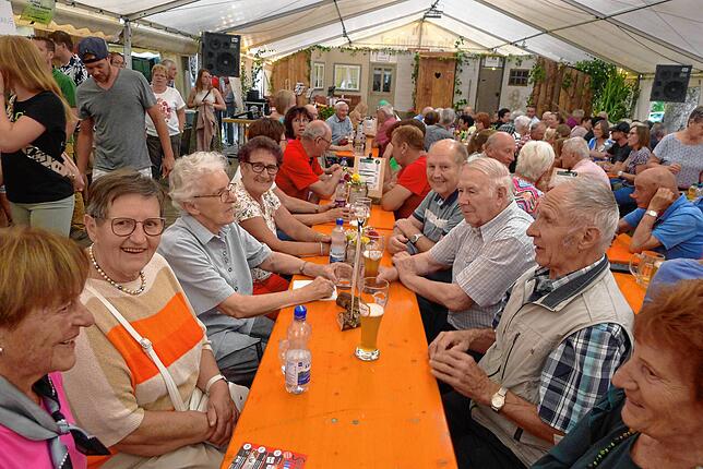 Im gut besuchten Festzelt in Limpach läßt es sich bei guter Stimmung gut aushalten; im Hintergrund die Kulissen für das Theater.
