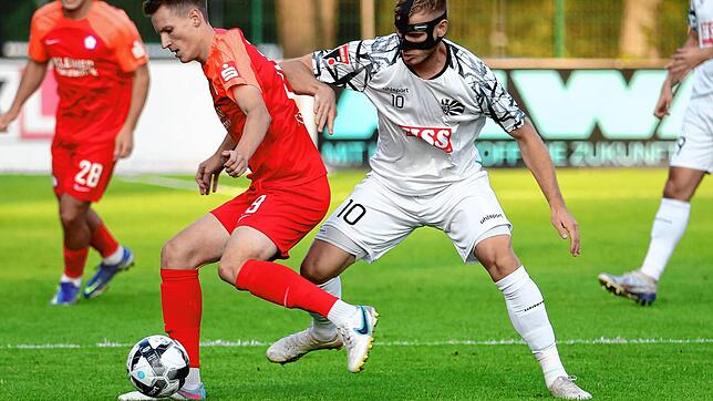 Der &bdquo;Mann mit der Maske&ldquo; Marcel Sökler versucht, dem Nöttinger Benedikt Fassler den Ball abzunehmen. Sökler ließ sich aber ...