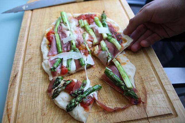 Oben: Schmeckt wie aus dem Steinofen: Gegrillte Pizza mit Parmaschinken, grünem Spargel und Parmesan.Unten: Süße Pizza vom Grill, hier ...