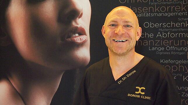 Klinikchef Andreas Dorow posiert vor einem riesigen Foto, das im Eingangsbereich der Waldshuter Dorow Clinic hängt.