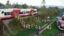 Um die große Höhe des Ausstiegs und den steilen Hang der Bahntrasse zu überwinden, haben die Feuerwehrleute Leitern mit improvisierten ...