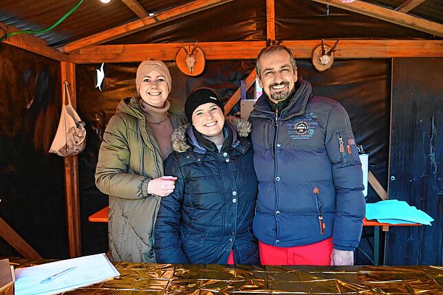 Fiona Waibel und Eva Lußmann von den Marketenderinnen sowie Marius Elsner von den Zimmereren bilden an einem der Stände ein Team.