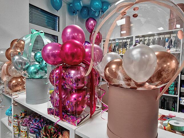 Geschenk-Ballons – ein Trend, der beispielsweise bei Baby-Partys beliebt ist: Ein Umschlag liegt in einem großen Heliumballon mit ...