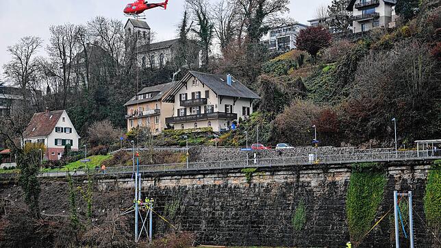 Der schwierigste Teil das Einsatzes: Arbeiter montieren das am Helikopter schwebende Oberteil des Pylons.