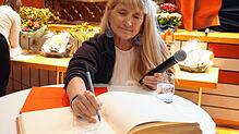 Eigentlich wollte sie nur zum Studium nach Deutschland, dann ist Brigid Wefelnberg geblieben. Hier trägt sie sich ins Goldene Buch der ...