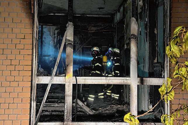 Feuerwehrleute mit Atemschutzgerät arbeiten in einem ausgebrannten Raum im Erdgeschoss im Marienkrankenhaus im Hamburger Stadtteil ...
