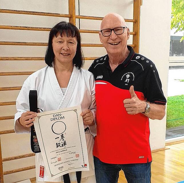 Silvia Apfelbeck mit ihrem stolzen Trainer und Ehemann Robert Apfelbeck, in der Hand hält sie ihren neuen Schwarzgurt.