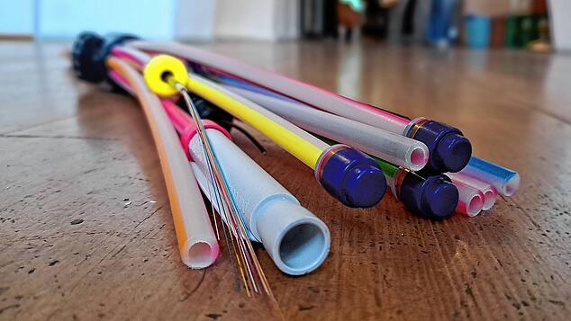 Bei der Verlegung von Glasfasern wird jedes einzelne der feinen bunten Kabel wie hier vorne links, in einem der dünnen Rohre verlegt.