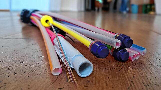 Bei der Verlegung von Glasfasern wird jedes einzelne der feinen bunten Kabel wie hier vorne links, in einem der dünnen Rohre verlegt.