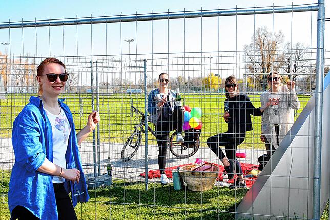 Eine Gruppe junger Frauen feiert am Grenzzaun in Konstanz Geburtstag.