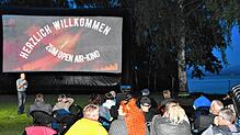 Eingekuschelt in warme Jacken und Decken, warten die Besucher auf den Start des Filmes im Open-Air-Kino an der Badestelle.