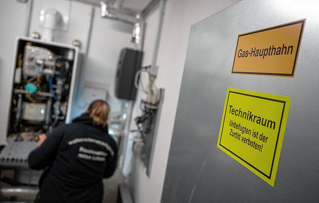 Eine Schornsteinfegerin arbeitet an einer Heizung. Welche müssen raus?