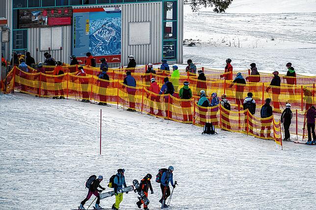 Nicht jeder hält immer den Abstand ein: Skifahrer stehen an einem österreichischen Skilift in einer Schlange.