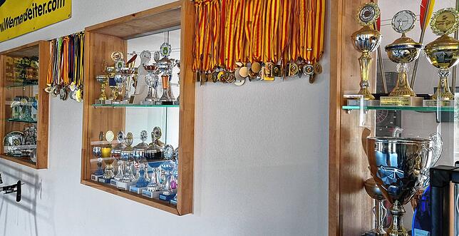 Kaum mehr zu zählen ist die Menge an Pokalen und Medaillen, die die Wand in der Trainingshalle säumen.