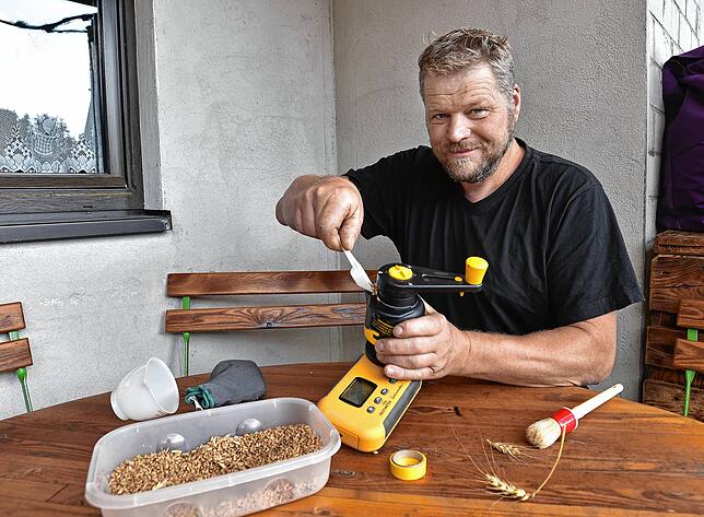 Christoph Meyer prüft im August 2021 die Getreidefeuchtigkeit seines Korns.