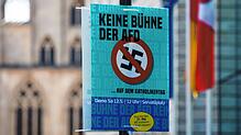 Ein Plakat mit der Aufschrift „Keine Bühne der AfD auf dem Katholikentag“ hängt schon 2018 vor dem historischen Rathaus in Münster. ...