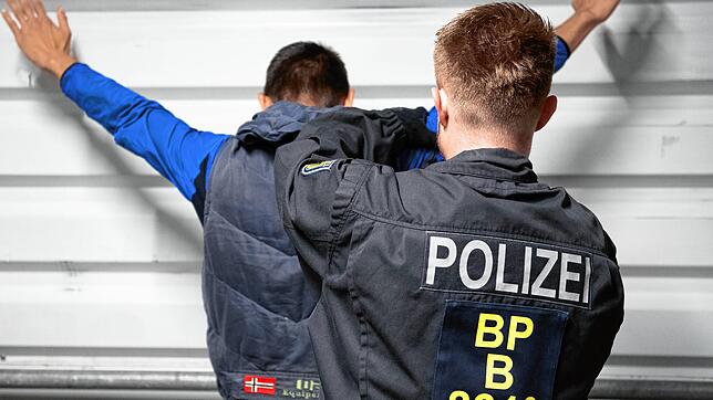 Ein Bundespolizist nimmt einen Mann fest. (Symbolbild)