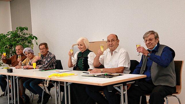 Mit einem Gläschen Sekt stößt der Vorstand des Heimat- und Geschichtsvereins Mönchweiler mit den bei der Hauptversammlung anwesenden ...